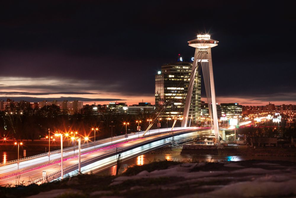 Der UFO-Turm auf dem Pylon der Most-SNP-Brücke bei Nacht, hell erleuchtet über der Stadt